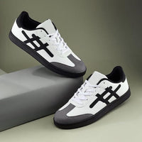 Pair of white and black sneakers on a gray and green gradient background