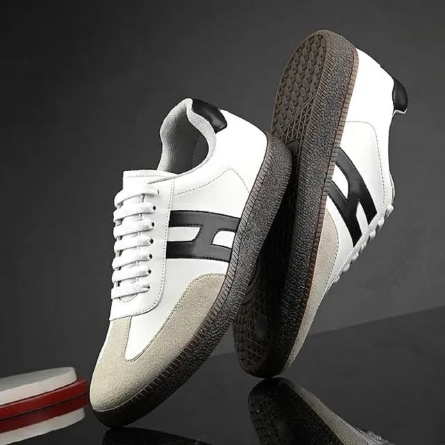White sneakers with black accents on a reflective surface and dark background
