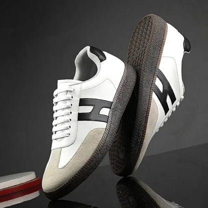 White sneakers with black accents on a reflective surface and dark background